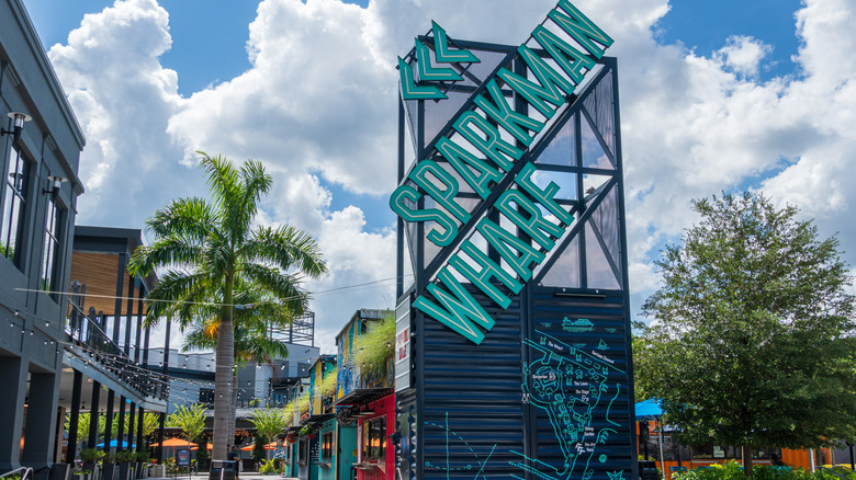 Sparkman Wharf sign with palm tress and buildings in back