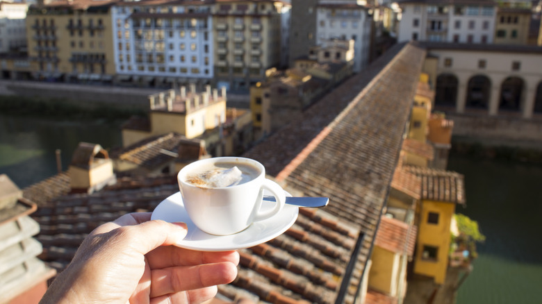 Someone holding a coffee at Ponte Vecchio