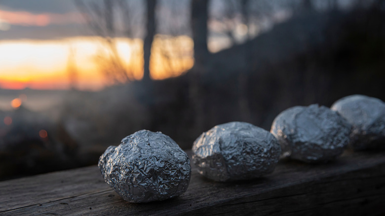 Potatoes in foil lined on a fence