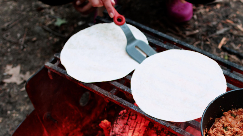 A hand serving tortillas