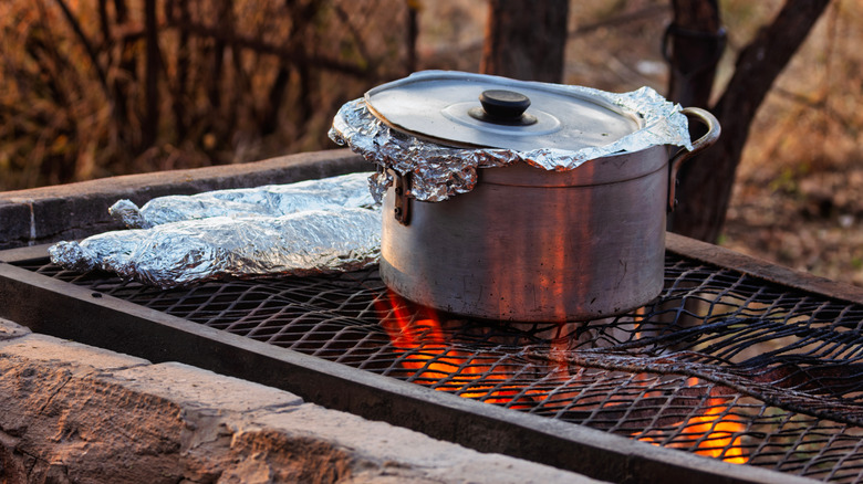 Foil items cooking on an outdoor grill