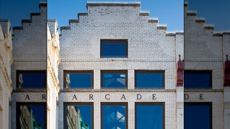 White brick facade with the word "arcade"