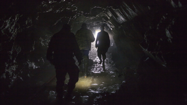 People walking toward a cave exit