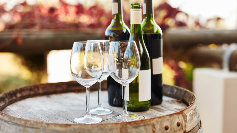 Wine glasses and bottles on a barrel