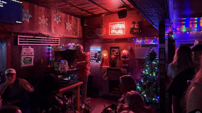 The interior of Santa's Pub, showing neon lights, Christmas decor, and a karaoke stage