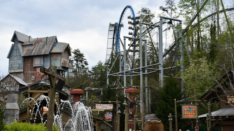 Dollywood Theme Park with rollercoaster and fountains shown in Sevierville, Tennessee during a cloudy day