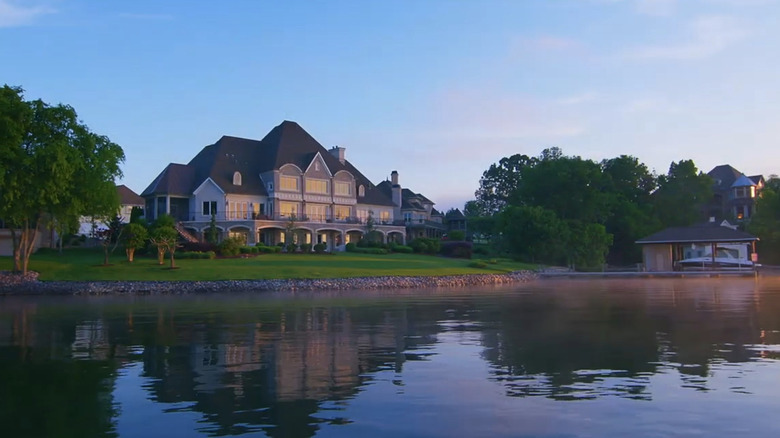 Rarity Bay main clubhouse surrounded by the lake and trees on summer day.