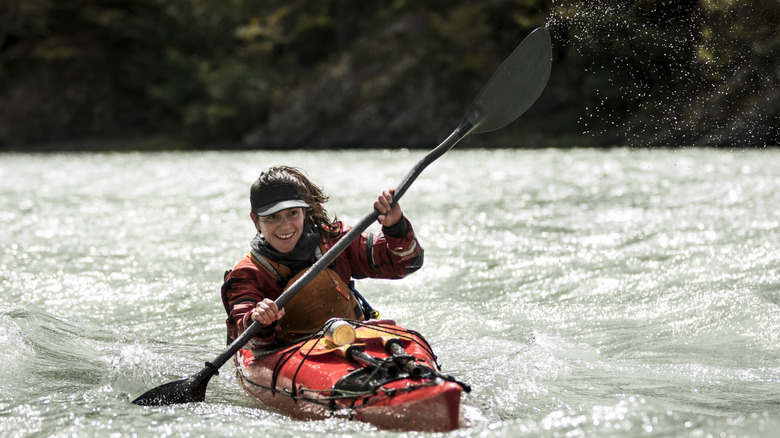 Woman in a kayak on river rapids