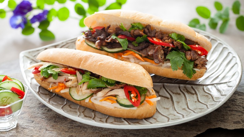Two banh mi sandwiches sit on a plate