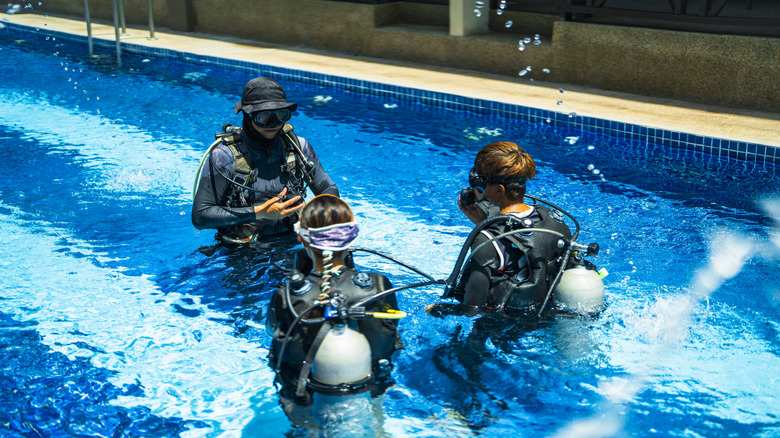 Students and instructor in the pool during scuba diving lesson.