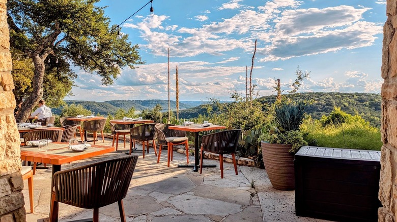 Outdoor dining on patio with hills in background at Miraval Austin
