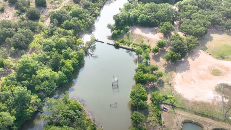 Large murky pool with abandoned equipment with trees