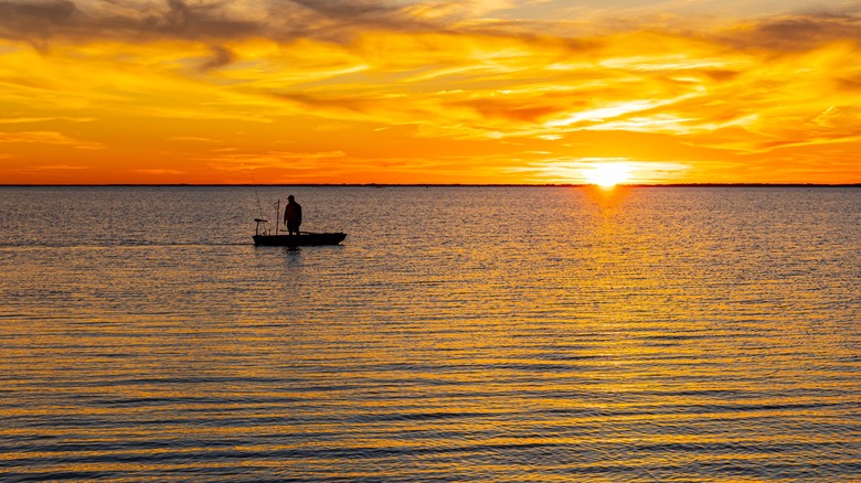 fisherman in small boat at Laguna Madre at sunset