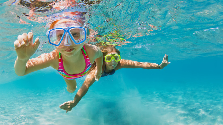 girl and mother snorkeling in clear waters