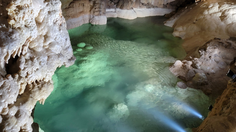 interior view of the Natural Bridge Caverns surrounding small body of clear water