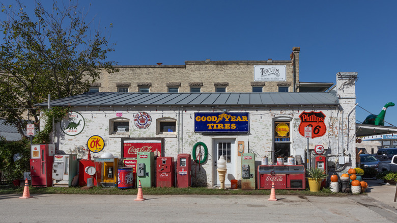 Small building with a variety of vintage signage on the side during the day.