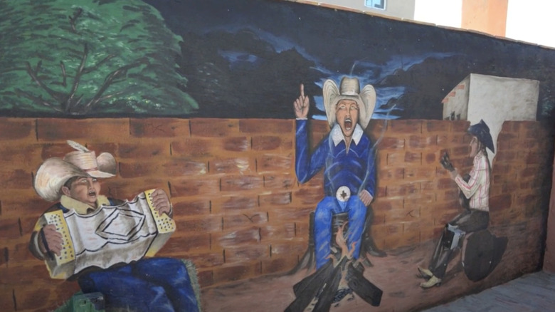 mural red brick painting of cowboys musical instruments