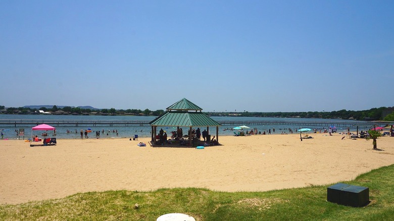 Umbrellas and picnic pavilion on the sandy Granbury Beach Park, Texas