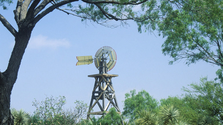 Windmill in Langtry against blue sky with trees