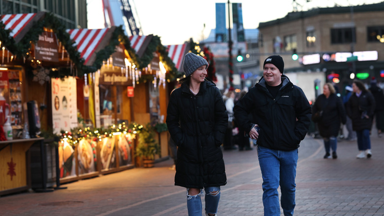 A man and a woman walking at the Christkindlmarket in Chicago