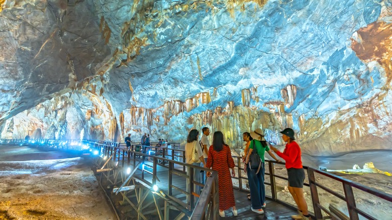 Tourists explore paradise cave