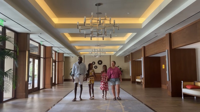 A family of four walks through the lobby of the Hyatt Regency Aruba