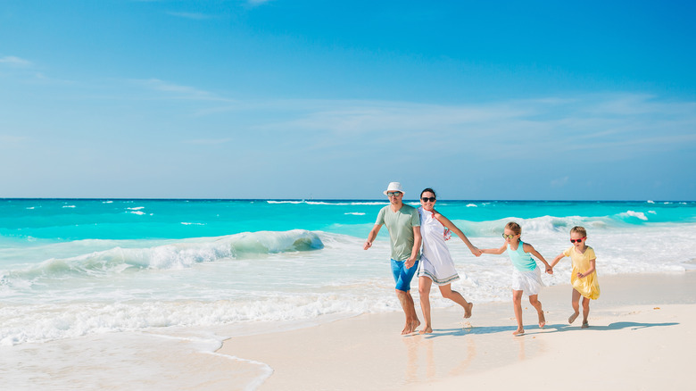 Parents with kids on the beach for a family vacation