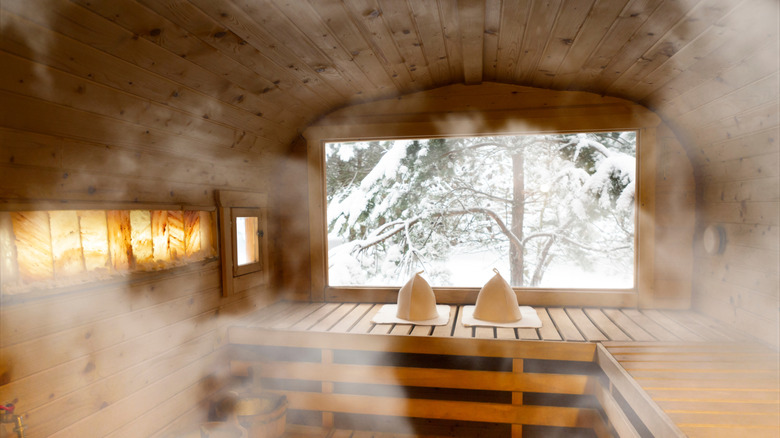 Finnish sauna interior filled with steam with window looking out on snowy landscape