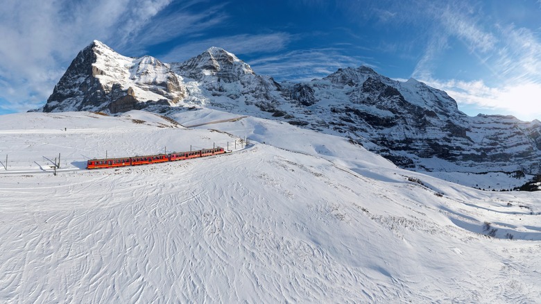 a red train traveling through a snowy landscape