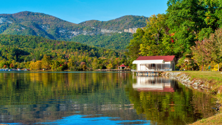 A boat house and dock on Lake Lure in North Carolina with mountains behind it.