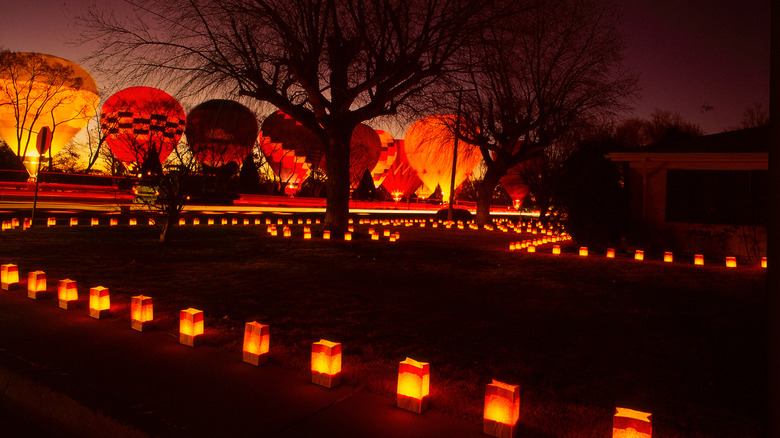 Backlit hot air balloons with pathway luminaries on Christmas Eve in Albuquerque, New Mexico