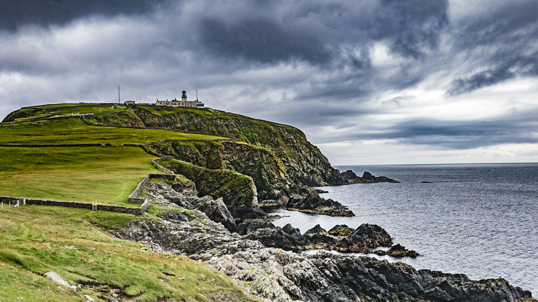Sumburgh Head Lighthouse in the south of mainland Shetland, set on a cliff with storm clouds behind