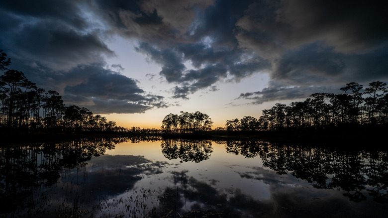 Colorful stormy sunset cloudscape reflected in calm water