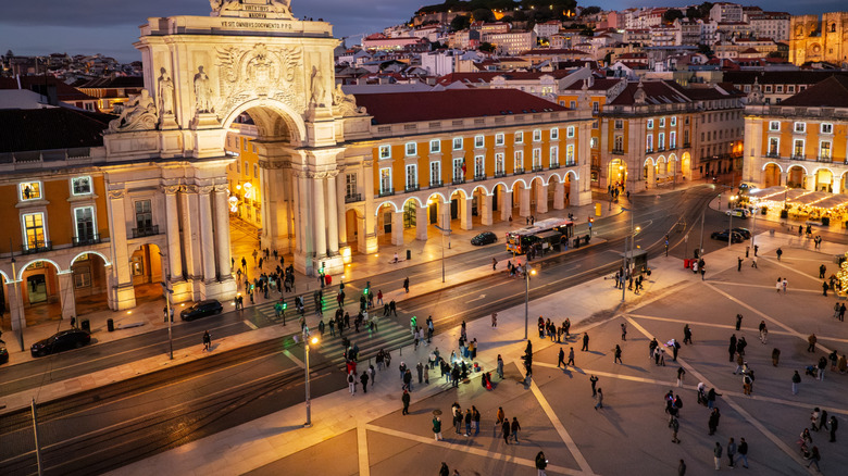 Christmas in Lisbon as Praca do Comercio, glowing with festive lights in the evening twilight