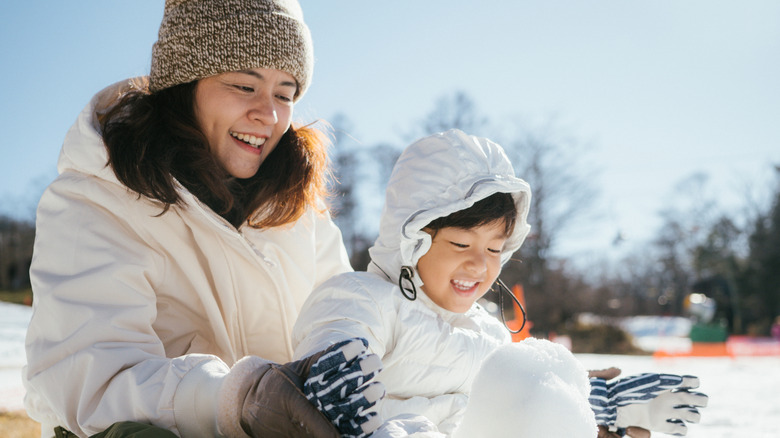 A family building a snowman at a winter festival