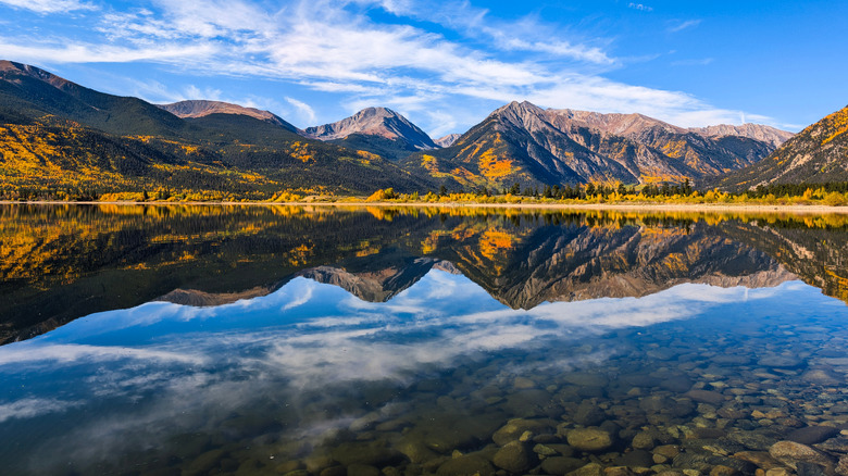 Aerial view of a mountain lake at Twin Lakes surrounded by golden aspen trees and autumn colors in the Rocky Mountains