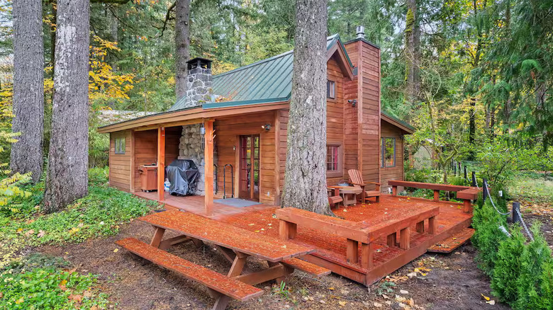 Exterior view of a redwood cabin with picnic table and patio