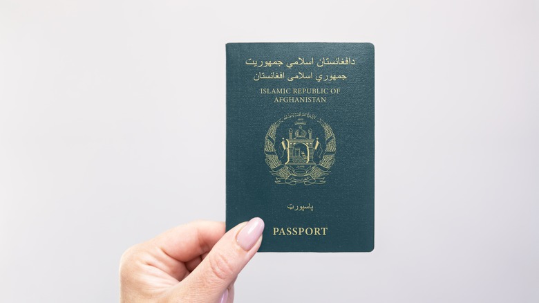 Hand holding a green passport for Afghanistan