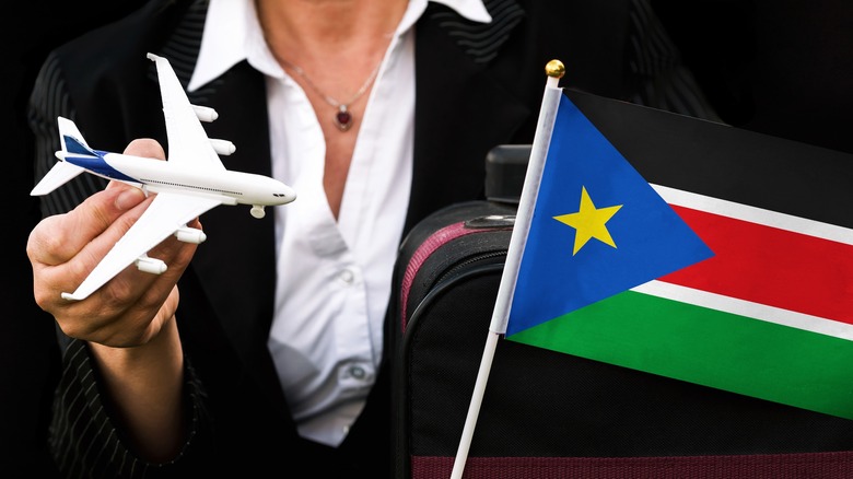 South Sudan's flag with a person holding a toy plane