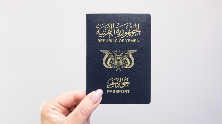 Hand holding a passport for the Republic of Yemen