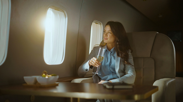 A woman in business class with a glass of champagne
