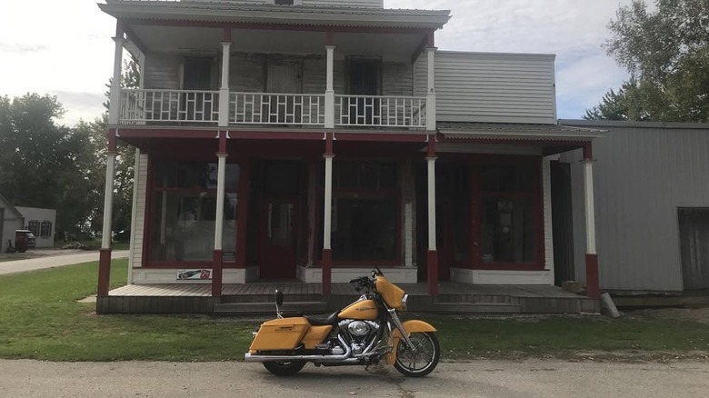 Yellow motorcycle in front of partially restored Kilmanagh General Store in Kilmanagh, Michigan