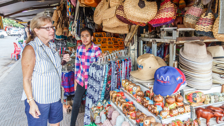 Senior woman browsing a Siem Reap market stall