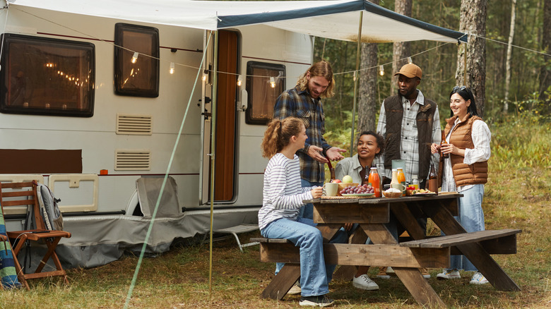 Group of friends enjoying a meal outside of an RV