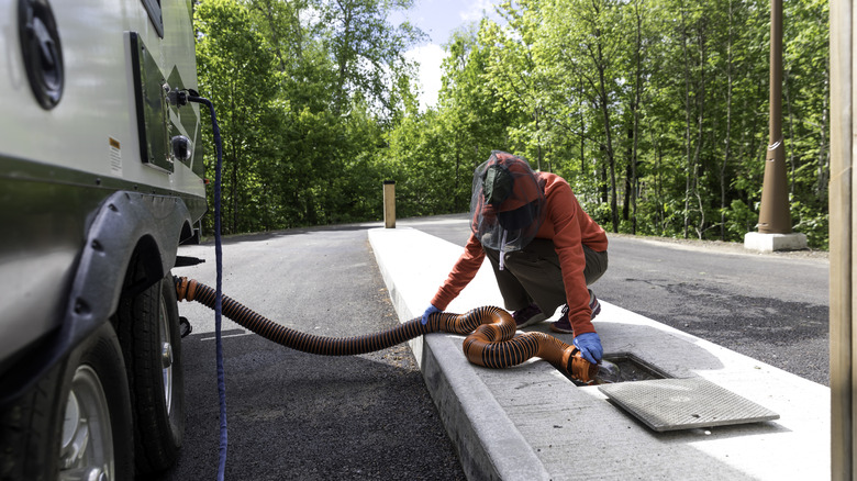Woman emptying RV sewage tank with hose