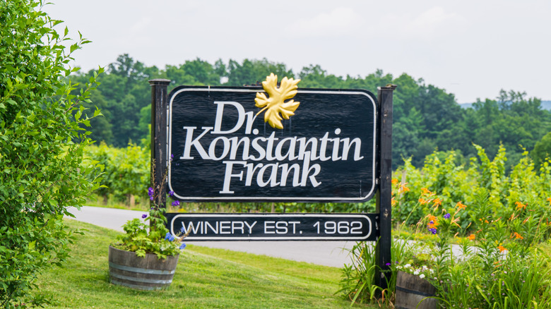 Entry sign for the Dr. Konstantin Frank Winery surrouded by grape vines and flowers.
