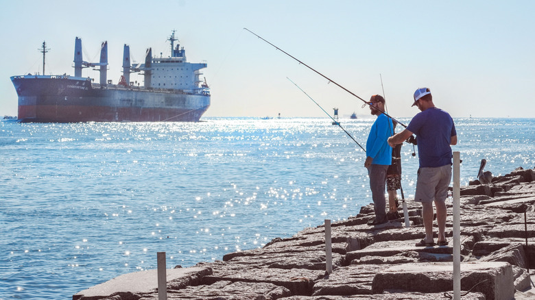 Two men fishing from the jetty in Port Aransas, Texas