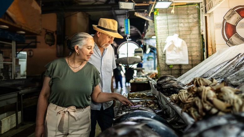Elderly couple browsing a fish market