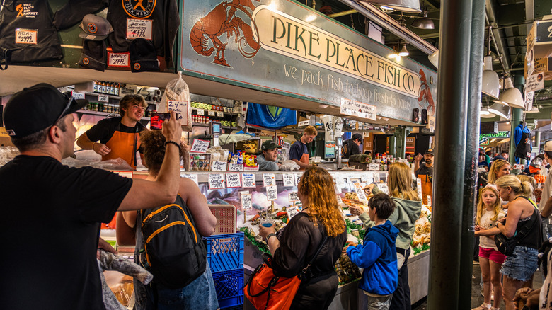 People purchasing seafood at a counter inside the Pike Place Fish Market