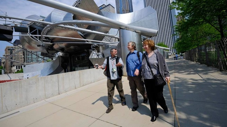 Tour guide showing travelers Chicago attraction
